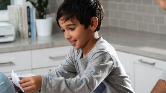 Ni&ntilde;o pegando recortes impresos con impresoas HP